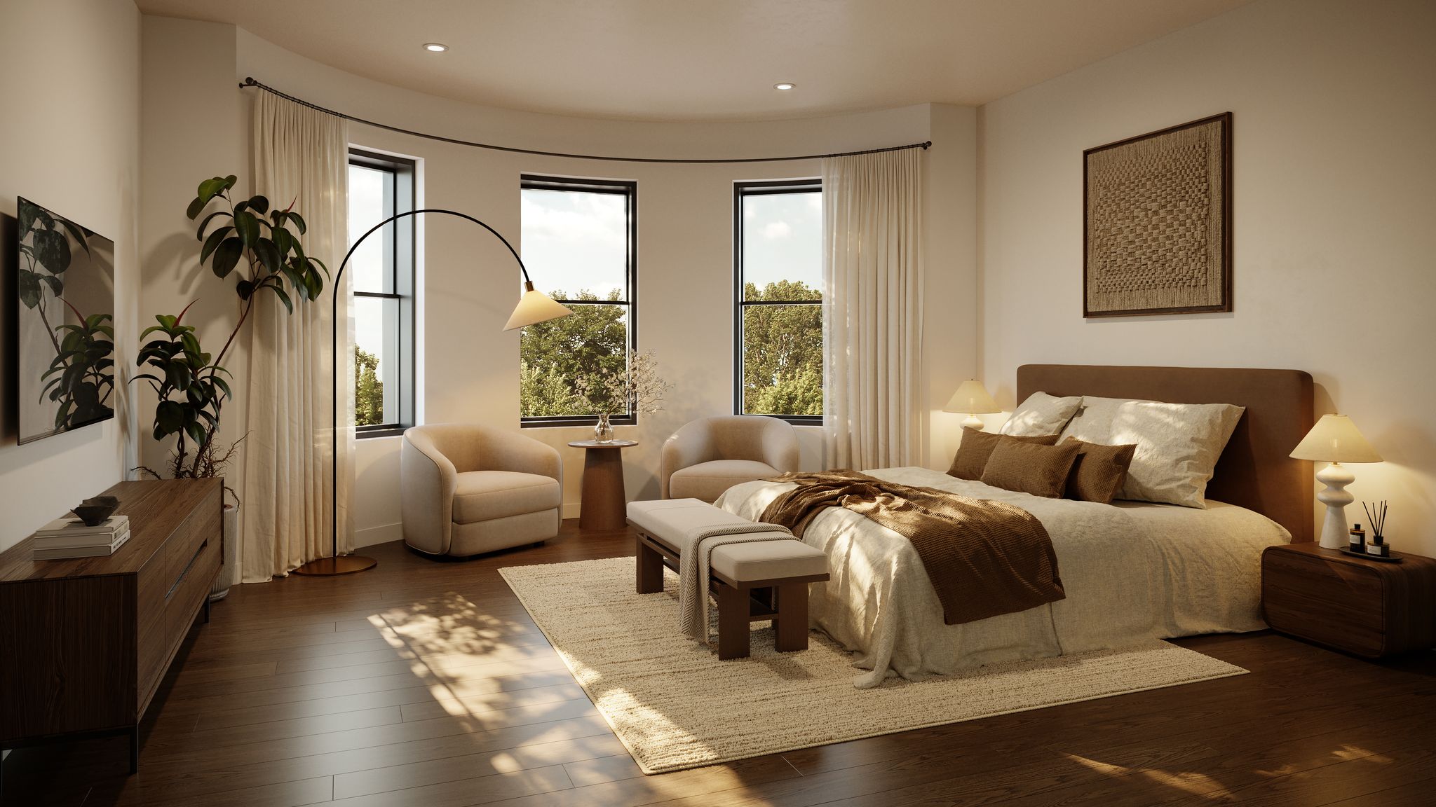 A bright primary bedroom featuring hardwood floors, a large bed, a sitting area by bay windows, and a decorative floor lamp.